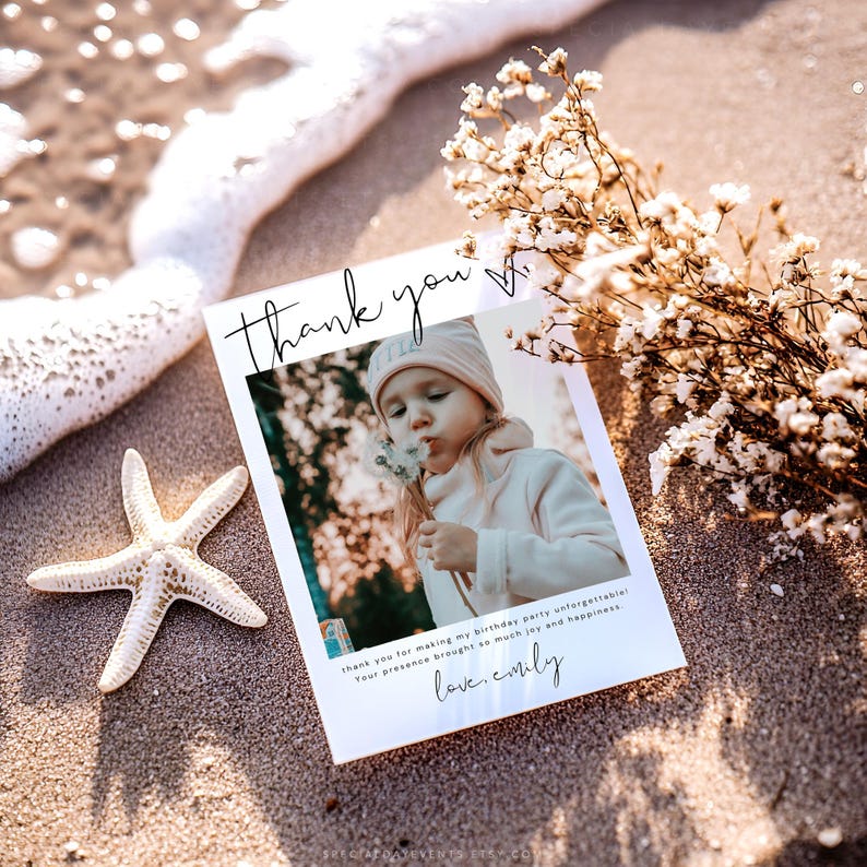 May include: A white thank you card with a photo of a child blowing on a dandelion, resting on sand with a starfish and flowers. The card reads "thank you" and "love, emily".