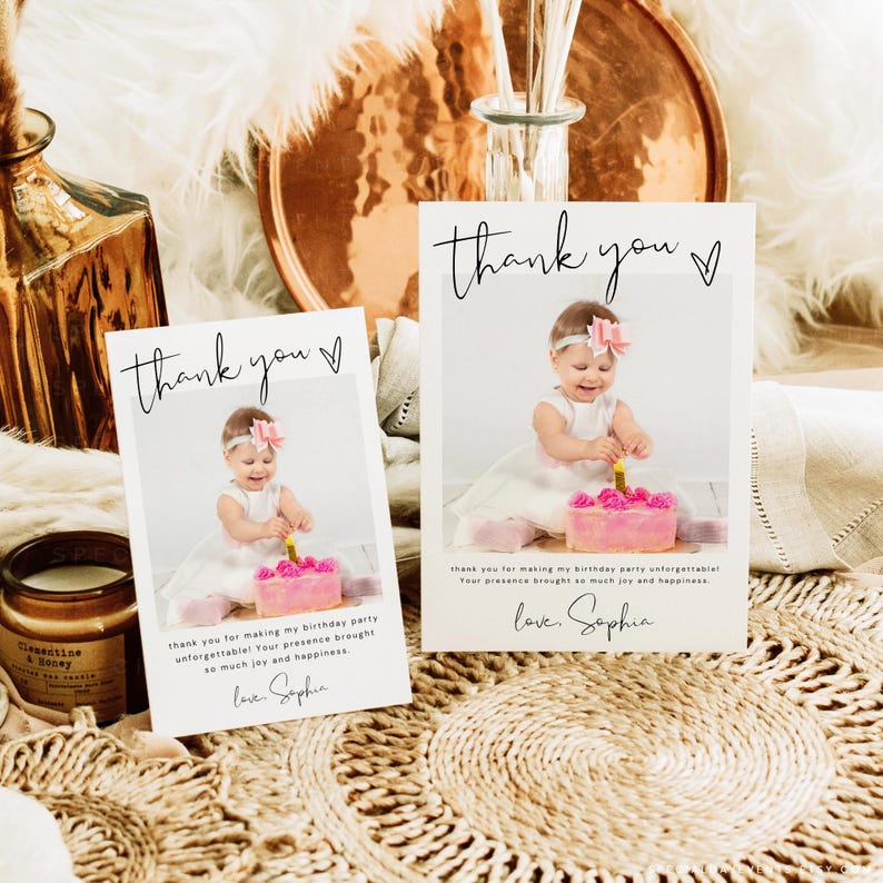 May include: Two thank you cards with a photo of a baby girl in a white dress, holding a lit candle on a pink cake. The cards have the text "thank you" and a message below, signed "love, Sophia."