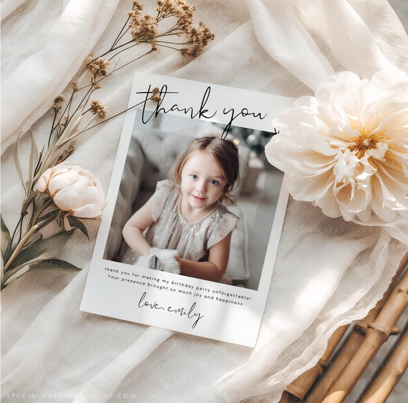 May include: A white thank you card with a photo of a young girl. The card has the words "thank you" in script, and a message about a birthday party. The card is surrounded by flowers and fabric.
