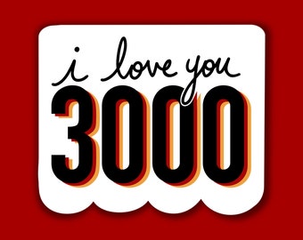 Könnte beinhalten: Weiße Karte mit schwarzem Text, der "i love you 3000" lautet. Der Text ist in einer fetten, handschriftlichen Schriftart. Die Zahl 3000 ist in einer großen, fetten Schriftart mit roten und gelben Umrissen.