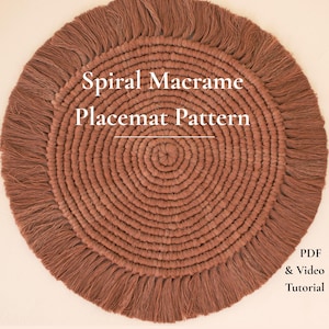 May include: A round, terracotta-colored macrame placemat featuring a spiral knot design with a fringed edge. The text "Spiral Macrame Placemat Pattern" is centered, with "PDF & Video Tutorial" printed in the bottom right corner.