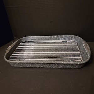 May include: A black and gray rectangular baking pan with a metal rack inside. The pan has a speckled finish.