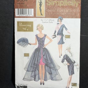 May include: Simplicity 9664 sewing pattern envelope for 11.5 inch fashion dolls. The cover features illustrations of three outfits labeled 1915, 1925, and 1920, showcasing dresses with various styles, including a high-low hem and a fur-trimmed coat.