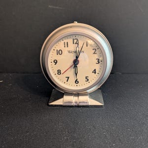 Vintage Westclox Footed Alarm Clock Requires 1 AA Battery. Chrome Case. The Face is 4.25" x 4". Travel Clock