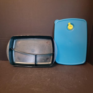 May include: A blue plastic divided food container with a matching lid. The lid has a yellow latch.