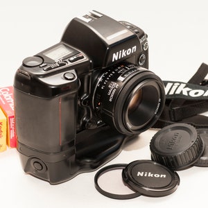Nikon F90X film camera with 50 mm f/1.8 Nikon lens and two KODAK 24 frames 200 iso - expired. Nikon MB 10 battery pack and strap.