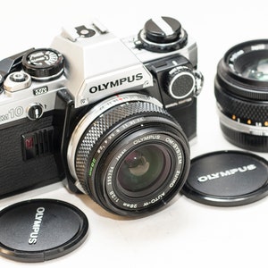 Olympus OM 10 with manual adapter and 2 zuiko lenses 50 mm f/1.8 and 28 mm f/2.8 EXCELLENT CONDITION.