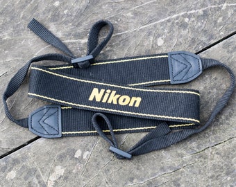 Nikon camera strap with NIKON logo.