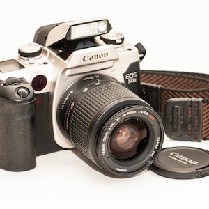 Canon EOS 50 E with 28-90 mm f/4-5.6 ULTRASONIC EF lens and original strap.