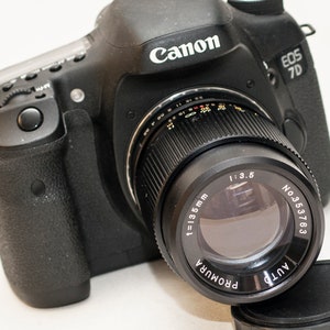 Obiettivo Canon EF-S compatibile con AUTO PROMURA 135 mm f/3.5 con attacco a vite M42 più anello adattatore.