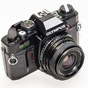 Vintage 35 mm Filmkamera Olympus OM 40 Programm mit Weitwinkelobjektiv 28 mm f/2,8 HANIMEX.