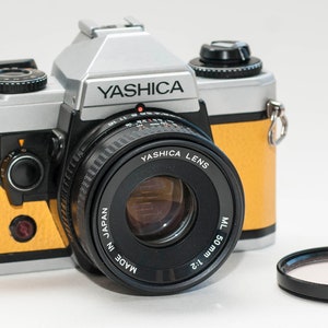 YASHICA FX-D Quartz  with 50 mm f2 lens. Silver with yellow skin.