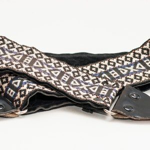 Vintage camerariem met patroon en camera-accessoires.