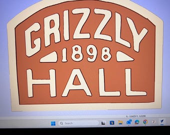May include: A digital design on a computer screen featuring a terracotta-colored sign with a cream-colored border. The text reads GRIZZLY in an arched font, the number 1898 in the center, and the word HALL below, all in a bold cream-colored font.