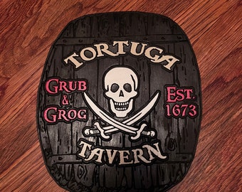 May include: A black, oval-shaped wooden sign with the words "Tortuga Tavern" and "Grub & Grog" in white and pink lettering. The sign features a skull and crossbones and the year "Est. 1673".