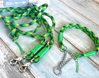 May include: A green and yellow patterned dog leash and collar set. The leash has two silver-colored clasps and a matching collar with a chain. The set is made of a durable rope material.