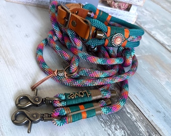 May include: A dog leash and collar set made of multicolored braided rope in shades of teal, pink, and orange. The collar features a brown leather strap with a metal buckle and a decorative circular emblem. The leash includes two bronze-toned metal clips and a small metal charm with the word love.