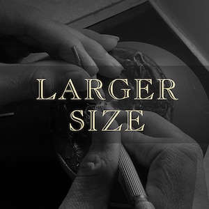 May include: A close-up of a person's hands working on a clay sculpture. The text "LARGER SIZE" is superimposed on the image.