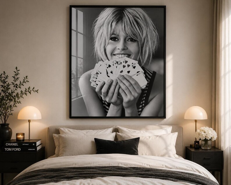 K&ouml;nnte beinhalten: Ein schwarz-wei&szlig; gerahmter Wandkunstdruck, der das Portr&auml;t einer l&auml;chelnden Person mit kurzem Haar zeigt, die einen F&auml;cher aus Spielkarten vor das Gesicht h&auml;lt. Das Bild f&auml;ngt einen nat&uuml;rlichen Ausdruck ein, wobei die Karten das Kinn verdecken.