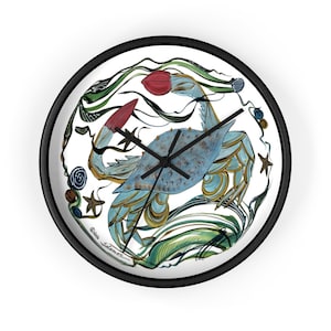 May include: A round wall clock with a black frame. The clock face features a blue crab illustration with red claws, surrounded by green and gold aquatic plants and starfish. The clock hands are black.