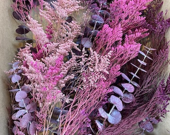 May include: A box filled with dried purple and pink eucalyptus and other floral stems.