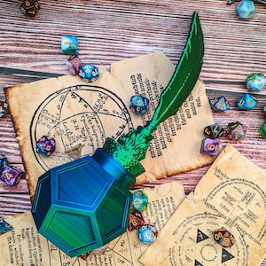 May include: An inkwell with a quill pen, surrounded by colourful dice and old paper with text and diagrams.