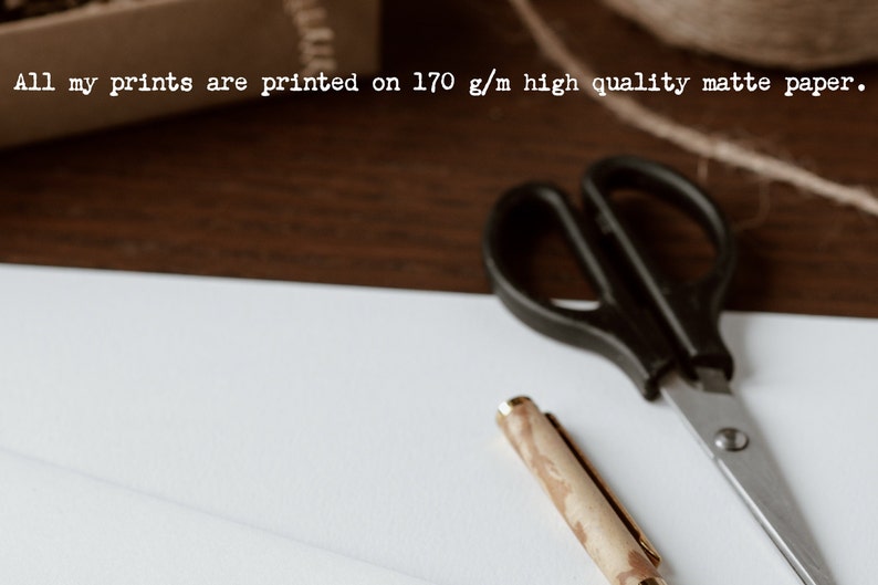 K&ouml;nnte beinhalten: Ein wei&szlig;es Blatt Papier mit einer schwarzen Schere und einem Holzstift mit goldener Spitze. Der Text "All my prints are printed on 170 g/m high quality matte paper." ist oben im Bild sichtbar.