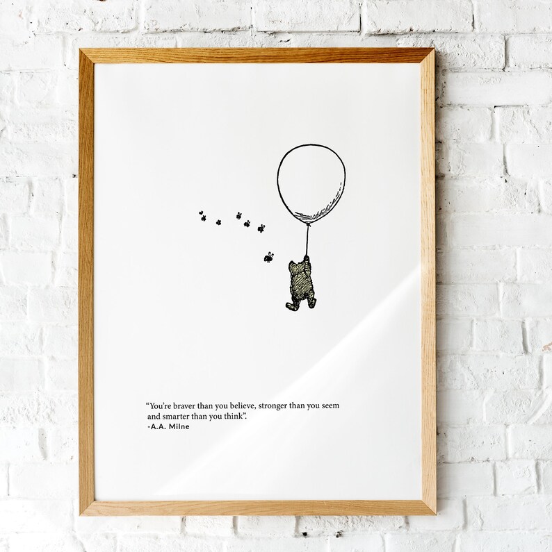 K&ouml;nnte beinhalten: Eine Schwarzwei&szlig;illustration von Winnie Puuh, der an einem Ballon festh&auml;lt, mit einem Zitat von A.A. Milne: "Du bist mutiger, als du glaubst, st&auml;rker, als du scheinst und kl&uuml;ger, als du denkst."