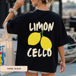 K&ouml;nnte beinhalten: Schwarzes T-Shirt mit einem gelben Zitronen-Grafik und den Worten "LIMON CELLO" in Wei&szlig;. Das Shirt zeigt zwei gelbe Zitronen mit gr&uuml;nen Stielen. Der Text "FARBE: BLACK" befindet sich unten.