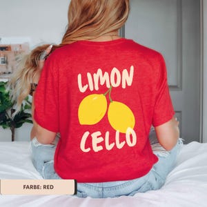K&ouml;nnte beinhalten: Rotes T-Shirt mit dem wei&szlig;en Schriftzug "LIMON CELLO" und einer gelben Zitronengrafik. Das Shirt besteht aus einem weichen Material und hat einen l&auml;ssigen Stil.