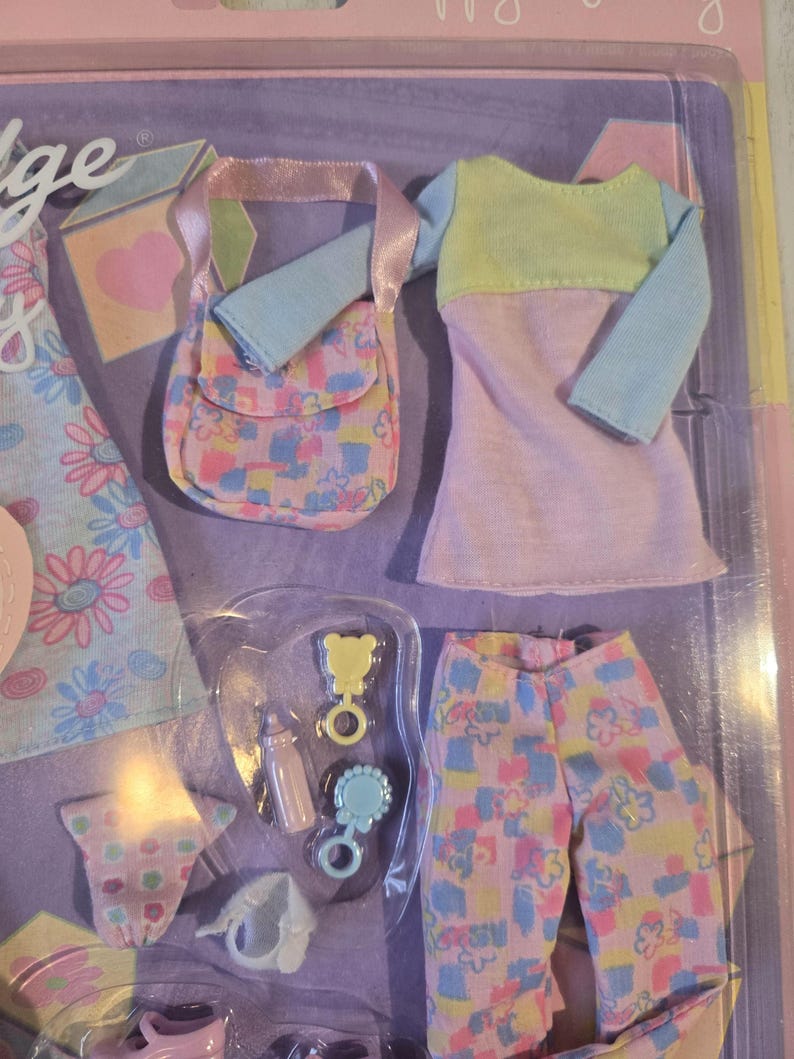 May include: A doll clothing set featuring a pastel color palette. The set includes a dress with blue sleeves and a yellow top, pants, a purse, and baby accessories. The accessories include a bottle, a rattle, and a bear-shaped toy.