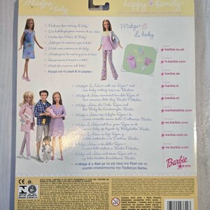 May include: Back of a Barbie doll package featuring Midge & baby dolls. The package has images of the dolls and text in multiple languages. The Barbie logo is visible, along with the text "happy family."