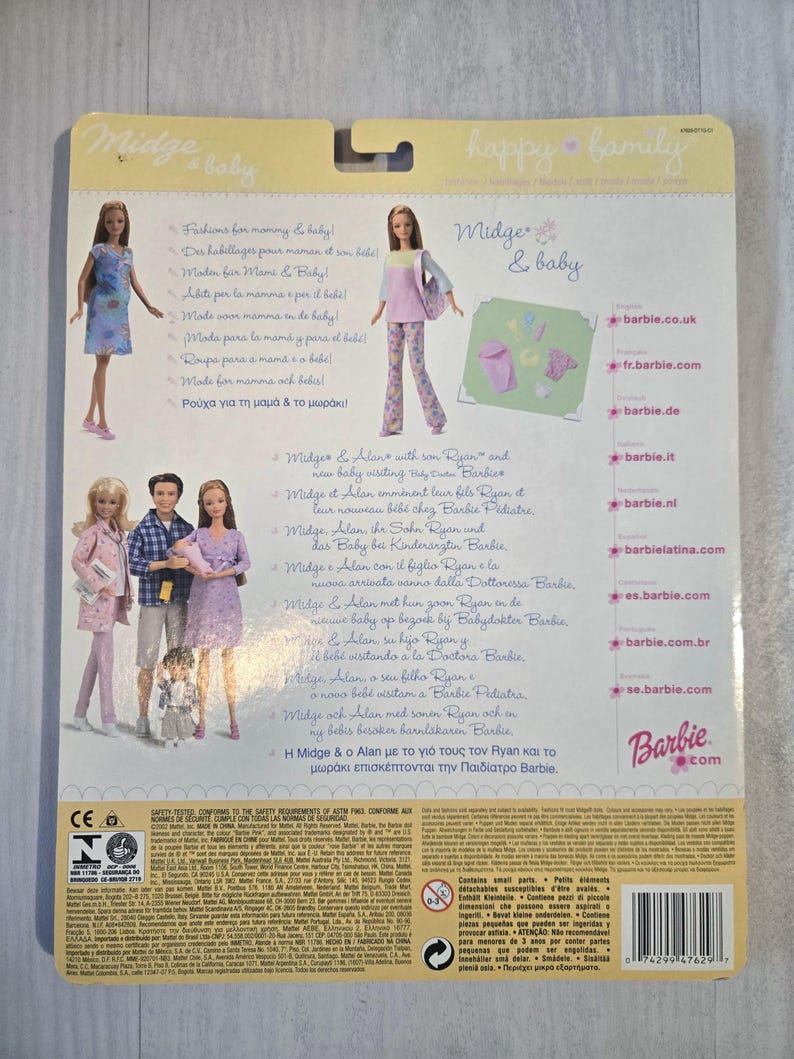 May include: Back of a Barbie doll package featuring Midge & baby dolls. The package has images of the dolls and text in multiple languages. The Barbie logo is visible, along with the text "happy family."