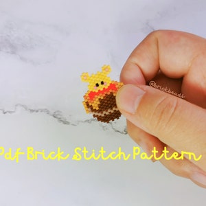 May include: A yellow and brown beaded Winnie the Pooh character holding a red heart. The text "Pdf Brick Stitch Pattern" is written in yellow below the character.