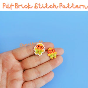 Peut inclure: Deux petites figurines colorées en perles avec des accents orange, jaune et vert. Les figurines sont sur une main sur un fond bleu clair.