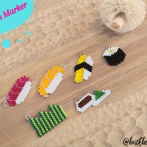 May include: Six different sushi-shaped stitch markers made with colorful beads. The stitch markers are on a wooden surface. The text "Stitch Marker" is in a blue and white circle in the top left corner of the image. The text "@brickbeads" is in the bottom right corner of the image.