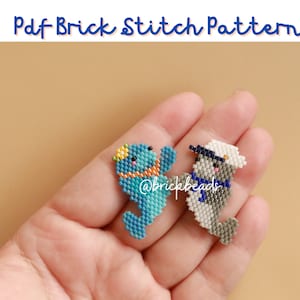 May include: Two beaded animal figures, a blue and white seahorse and a grey and white seal, are shown in a hand. The seahorse has a yellow crown and the seal has a white sailor hat. The text "@brickbeads" is visible on the seahorse.