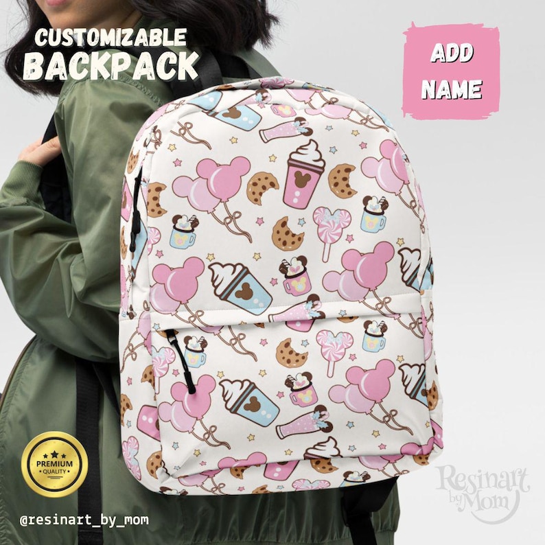 May include: White backpack with a repeating pattern of pink balloons, cookies, and ice cream cones. The backpack has the text "CUSTOMIZABLE BACKPACK" and "ADD NAME" on the front. The backpack is decorated with a variety of cartoon images.