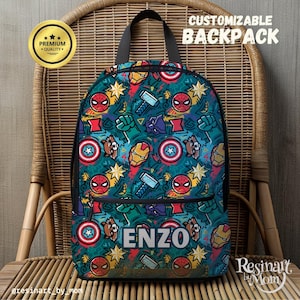 May include: A blue and green backpack with a colorful pattern of superheroes, including Spiderman, Captain America, Iron Man, and Thor. The backpack has a black zipper and a black handle. The name "ENZO" is printed in white on the front of the backpack.
