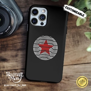May include: Black phone case featuring a red star design within a gray and white circular pattern. The case has the word "CUSTOMIZABLE" in white script. The case is on a wooden surface.