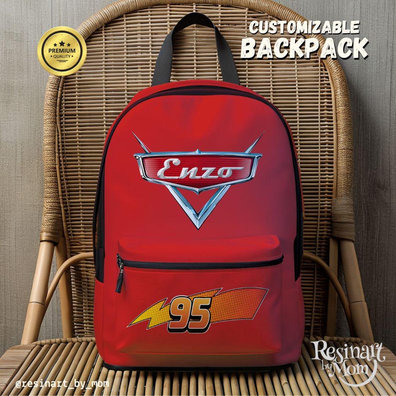 Puede incluir: Mochila roja con cremallera y correas negras, con el texto "Enzo" en un emblema plateado y el n&uacute;mero "95" con un dise&ntilde;o de rayo. La mochila est&aacute; etiquetada como "Mochila personalizable" y "Calidad Premium".