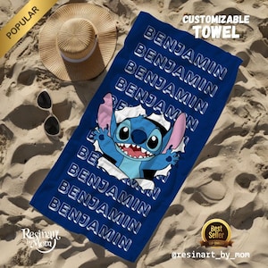 K&ouml;nnte beinhalten: Ein blaues Strandtuch mit einer Zeichentrickfigur Stitch, die aus einem Loch schaut. Das Handtuch tr&auml;gt den Namen "Benjamin", der mehrmals in wei&szlig;er Schrift wiederholt wird.
