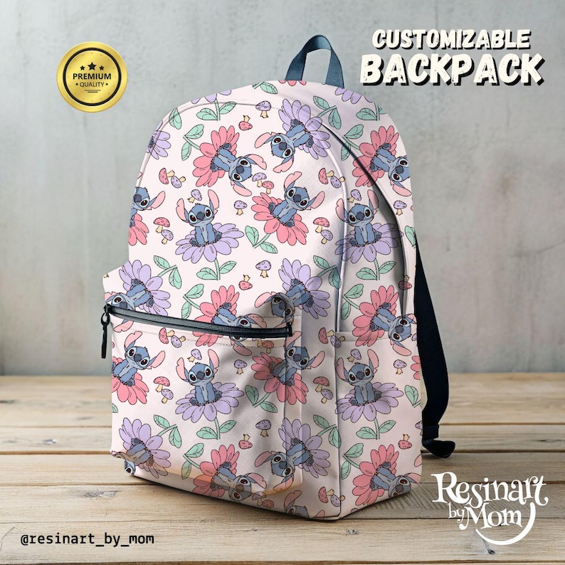May include: A customizable backpack with a white background and a repeating pattern of blue Stitch characters from the Disney movie Lilo & Stitch. The characters are sitting on pink and purple flowers with green stems and leaves. There are also small pink mushrooms scattered throughout the pattern. The backpack has a black zipper and black straps. The text "CUSTOMIZABLE BACKPACK" is in black text at the top of the image. The text "Resinaft by Mom" is in black text at the bottom of the image.