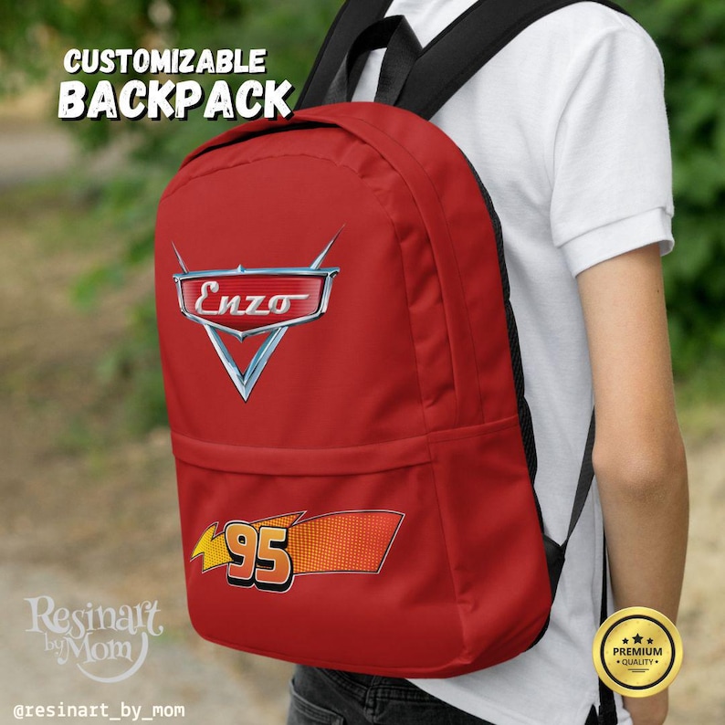 Puede incluir: Mochila roja con el texto "CUSTOMIZABLE BACKPACK" en la parte superior. La mochila presenta el logotipo "Enzo" y el n&uacute;mero "95" en un dise&ntilde;o tem&aacute;tico de carreras. La mochila la lleva una persona.