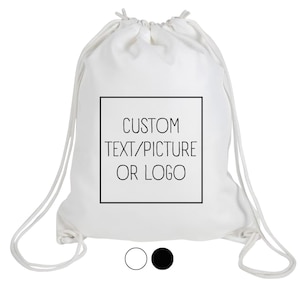 Peut inclure: Sac à cordon blanc avec le texte "CUSTOM TEXT/PICTURE OR LOGO" dans un carré noir. Le sac a des cordons blancs et un choix de cercle noir ou blanc en bas.