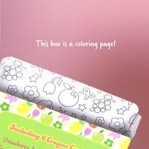 May include: A white box with a black and white coloring page of fruits and flowers. The box says "This box is a coloring page!" and "Including 6 Crayon Crayons".