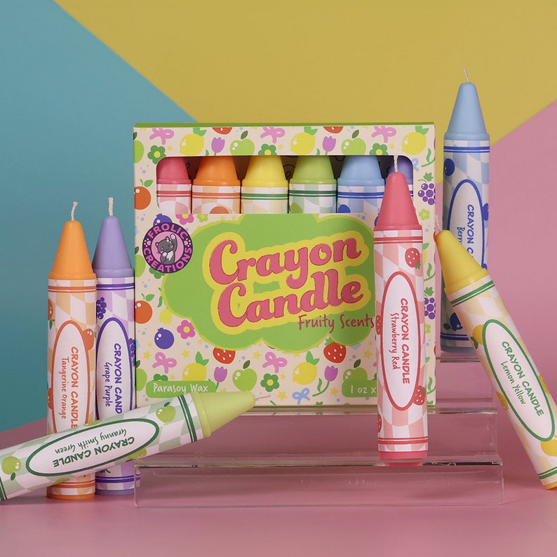 May include: A set of eight crayon-shaped candles in various colors and fruity scents. The candles are arranged in a box with a colorful design and the text "Crayon Candle Fruity Scents".