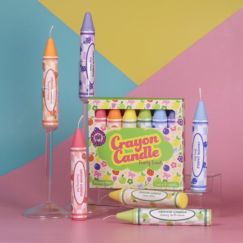 May include: A set of six crayon candles in assorted fruity scents. The candles are shaped like crayons and are packaged in a colorful box with a crayon candle design. The scents include grape purple, tangerine orange, berry blue, strawberry red, lemon yellow, and granny smith green.