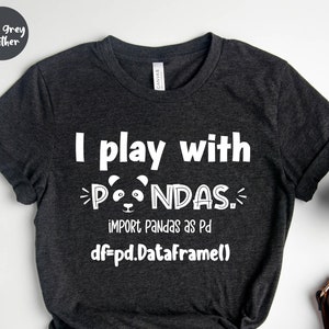 May include: Dark grey heather t-shirt with the text "I play with pandas" and the code "import pandas as pd, df=pd.DataFrame()" in white. A panda face graphic is in the middle of the text. A watch, a cup of coffee, and a brown purse are also in the image.