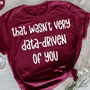 Könnte beinhalten: Ein T-Shirt in der Farbe Weinrot mit dem Text "that wasn't very data-driven of you" in weißer Schrift.